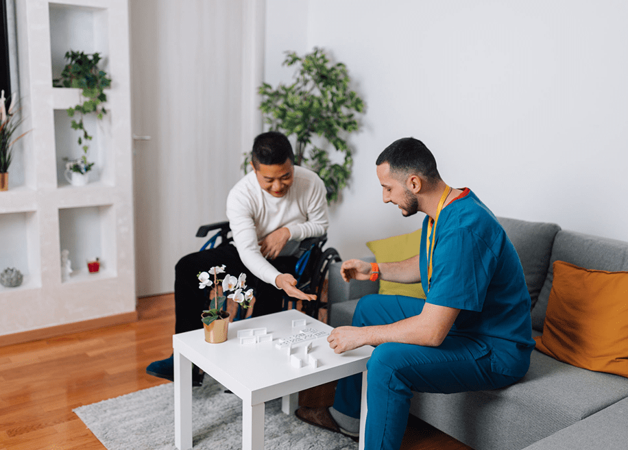 Man and caregiver playing board game together.
